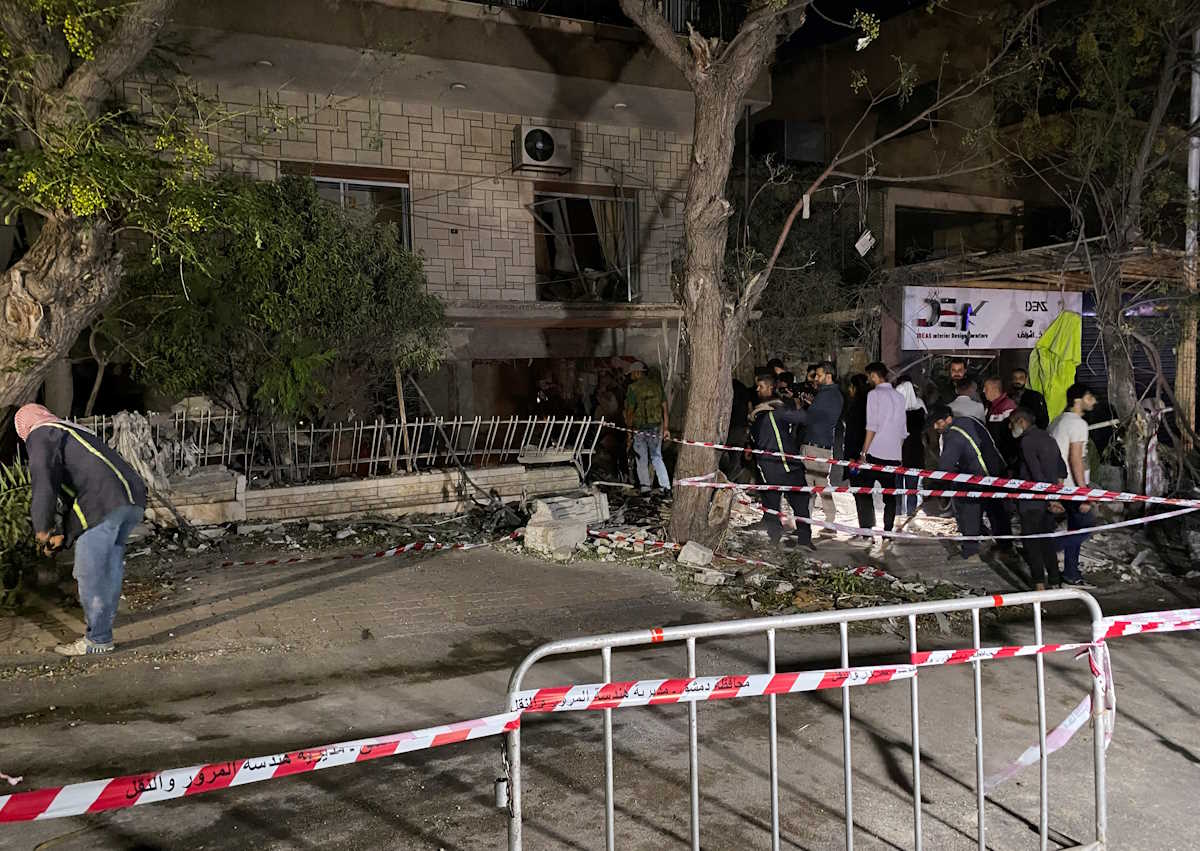 People stand at the site of an Israeli airstrike that targeted a residential building in the Mezzah suburb in western Damascus, according to Syrian state media, Syria October 2, 2024. REUTERS