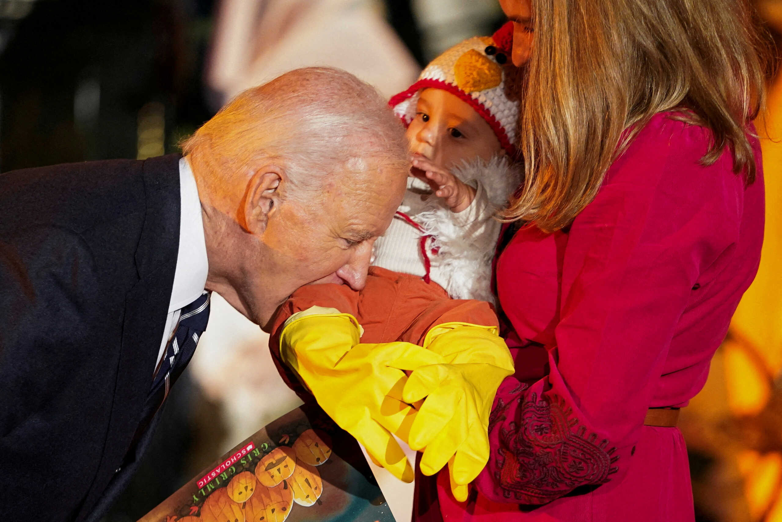 U.S. President Joe Biden playfully bites a baby during a trick-or-treaters celebration for Halloween at the White House in Washington, U.S., October 30, 2024. REUTERS