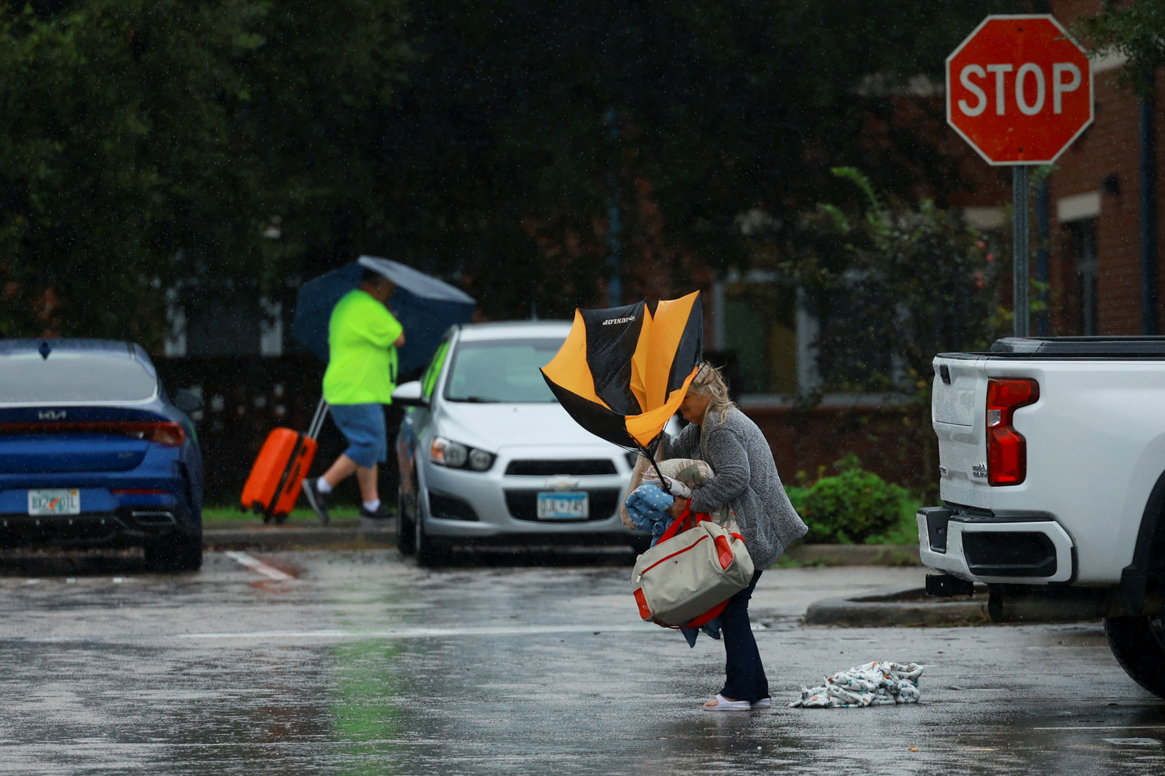 A woman holds an umbrella while arriving at a shelter as Hurricane Milton approaches, in Lakeland, Florida, U.S., October 9, 2024.  REUTERS