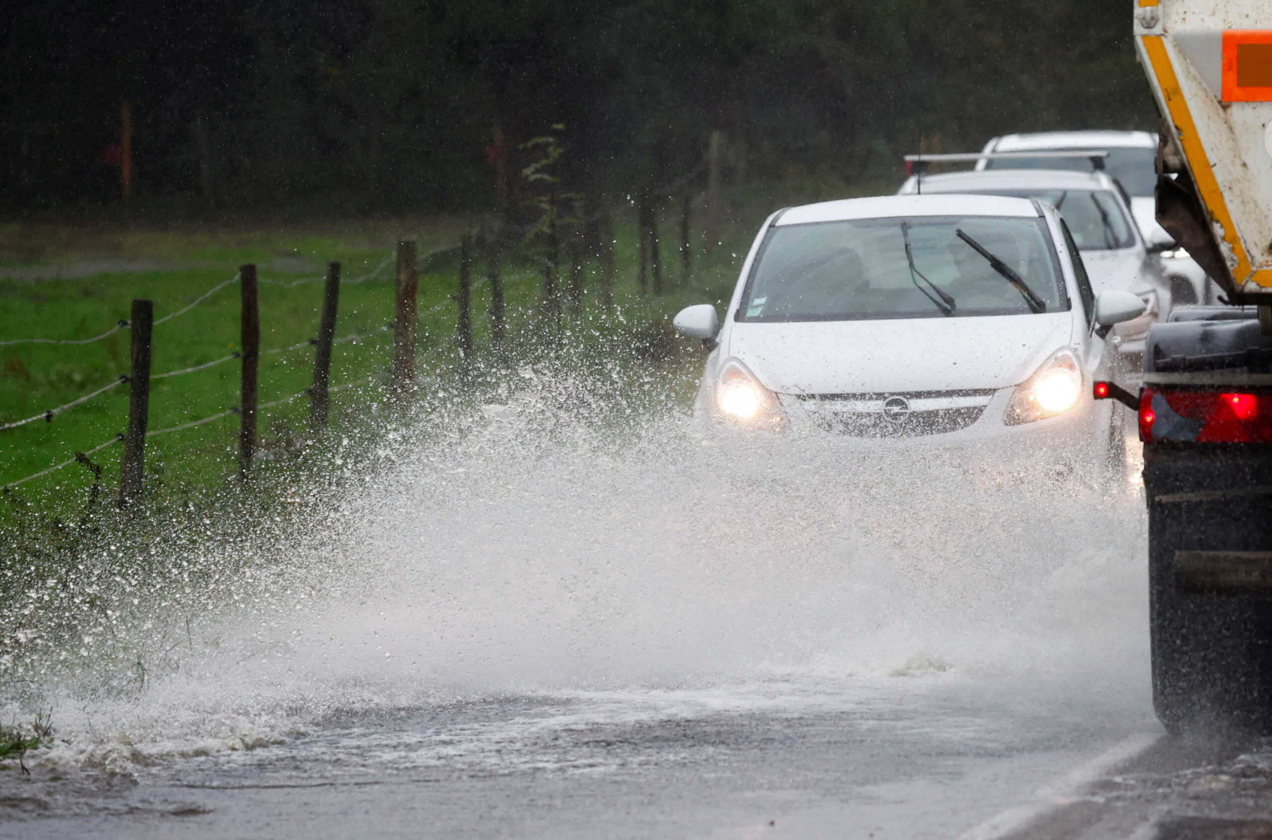 FILE PHOTO: Vehicles drive along a flooded road as heavy rains continue in Vertou near Nantes, France October 9, 2024. REUTERS