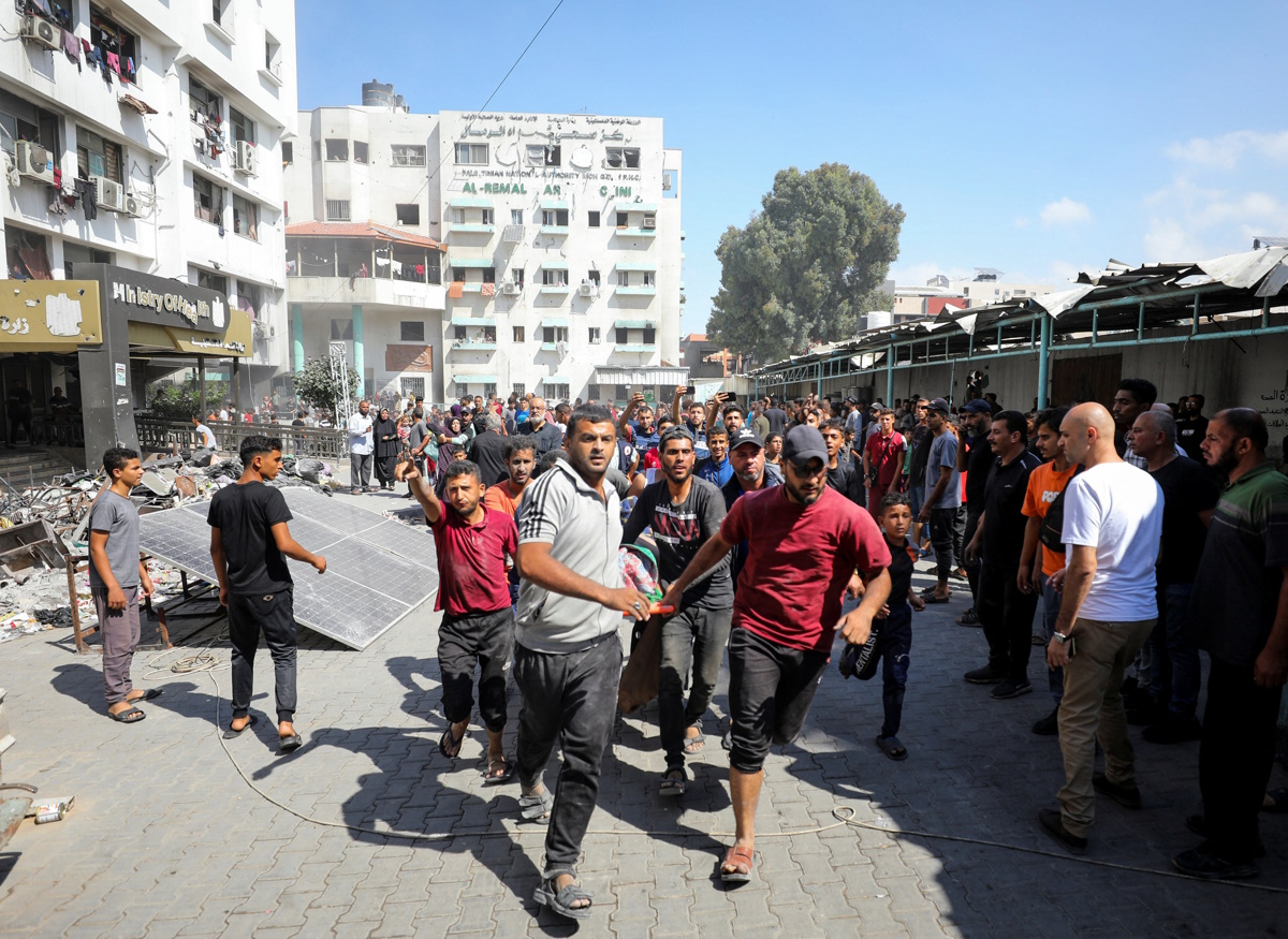 Palestinians carry a casualty in the aftermath of an Israeli strike at al-Remal clinic, which had been sheltering displaced people, amid the Israel-Hamas conflict in Gaza City, October 10, 2024. REUTERS