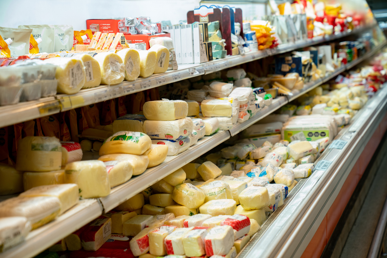 Delicious variety of cheese in the dairy aisle refrigerated section of the supermarket - No people