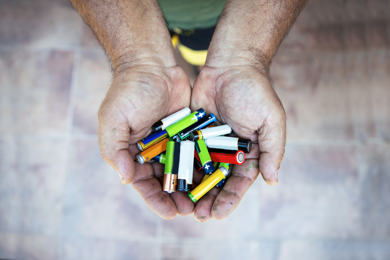 Man hands with variety of Batteries. Close up. Copy space