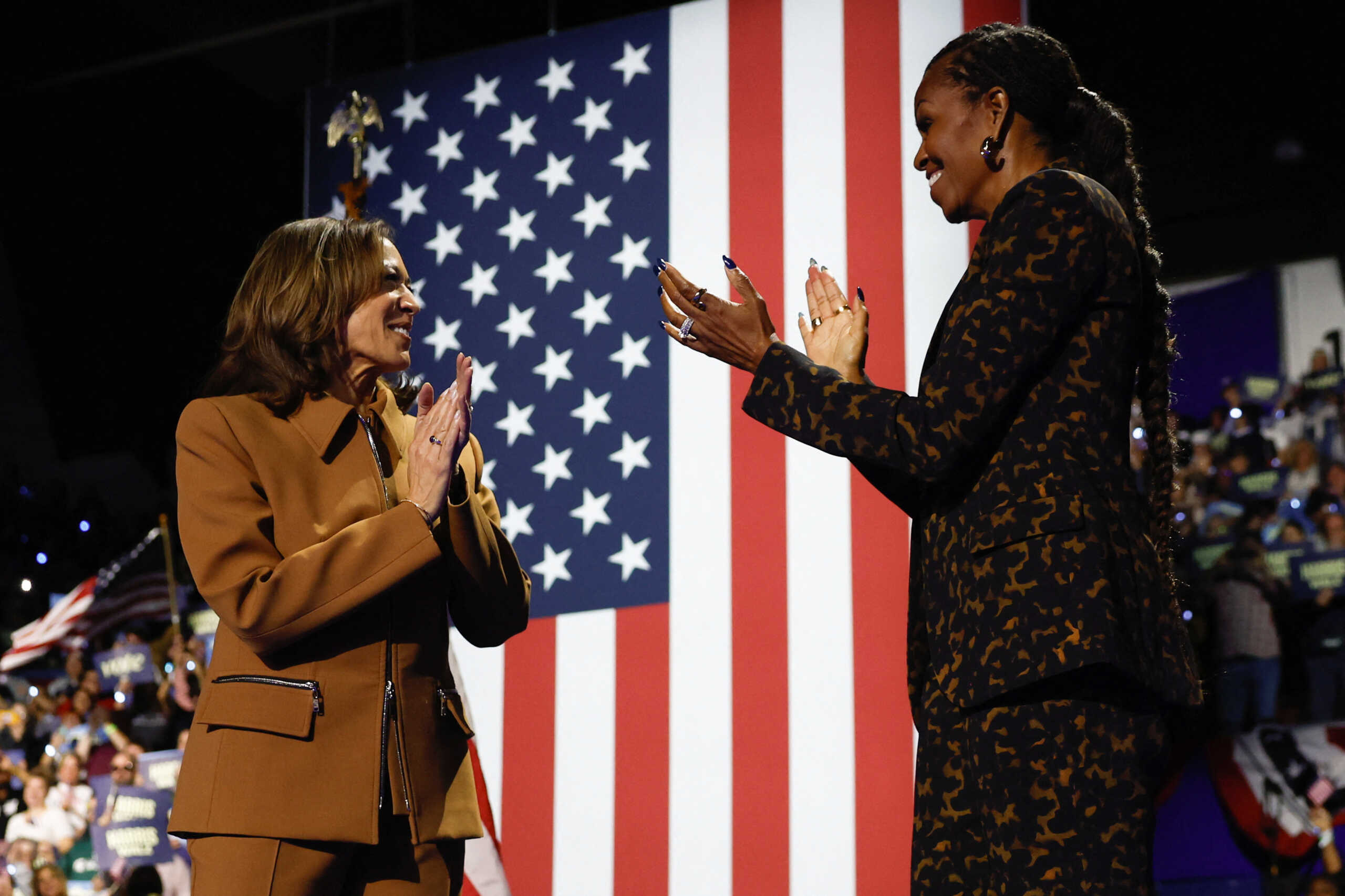 Former U.S. first lady Michelle Obama and Democratic presidential nominee U.S. Vice President Kamala Harris appear on stage during a campaign event at Wings Event Center in Kalamazoo, Michigan, October 26, 2024. REUTERS