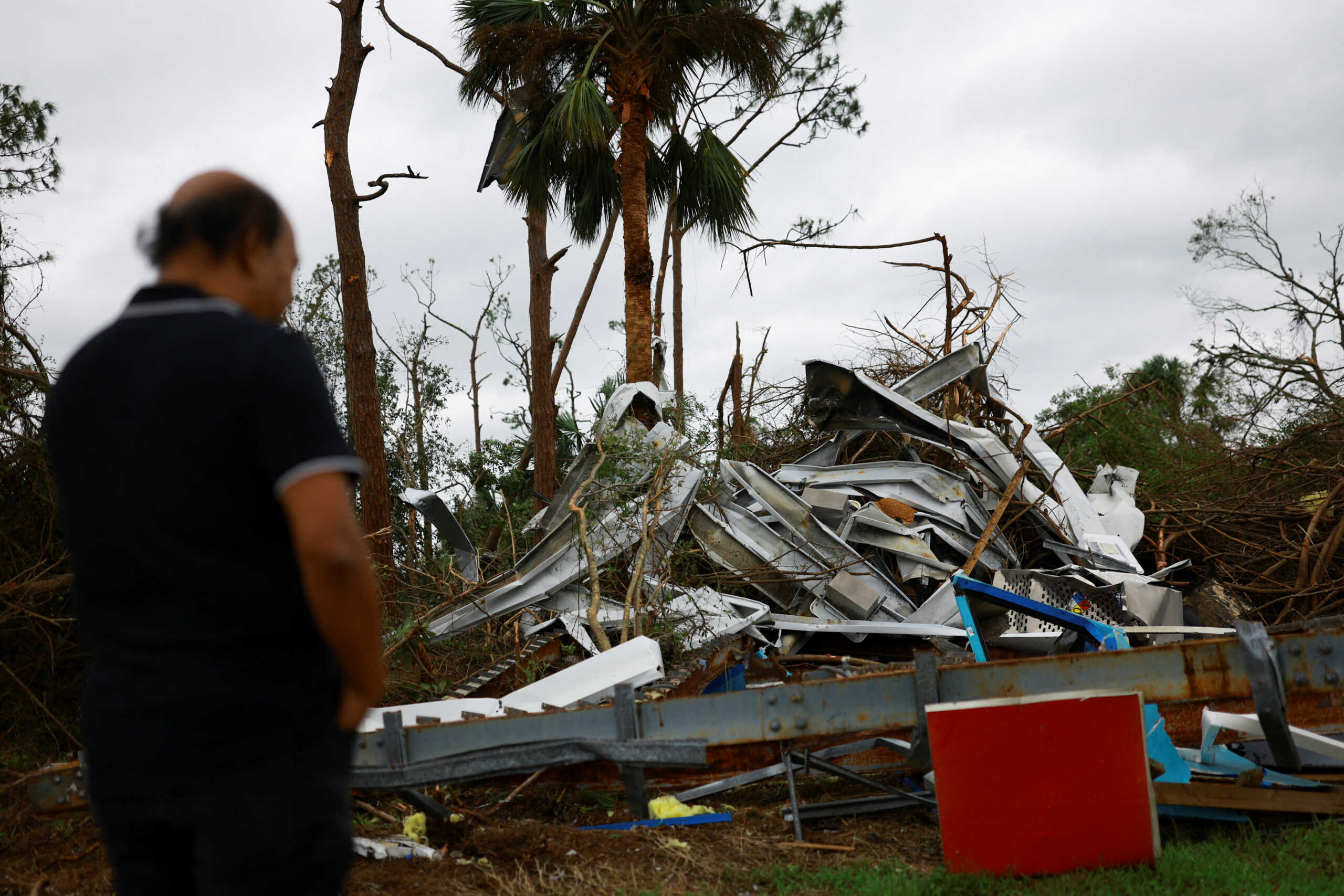 A person looks at the damage caused by a tornado after Hurricane Milton made landfall, in Lakewood Park, near Fort Pierce, in St. Lucie County, Florida, Florida, U.S., October 10, 2024.  REUTERS