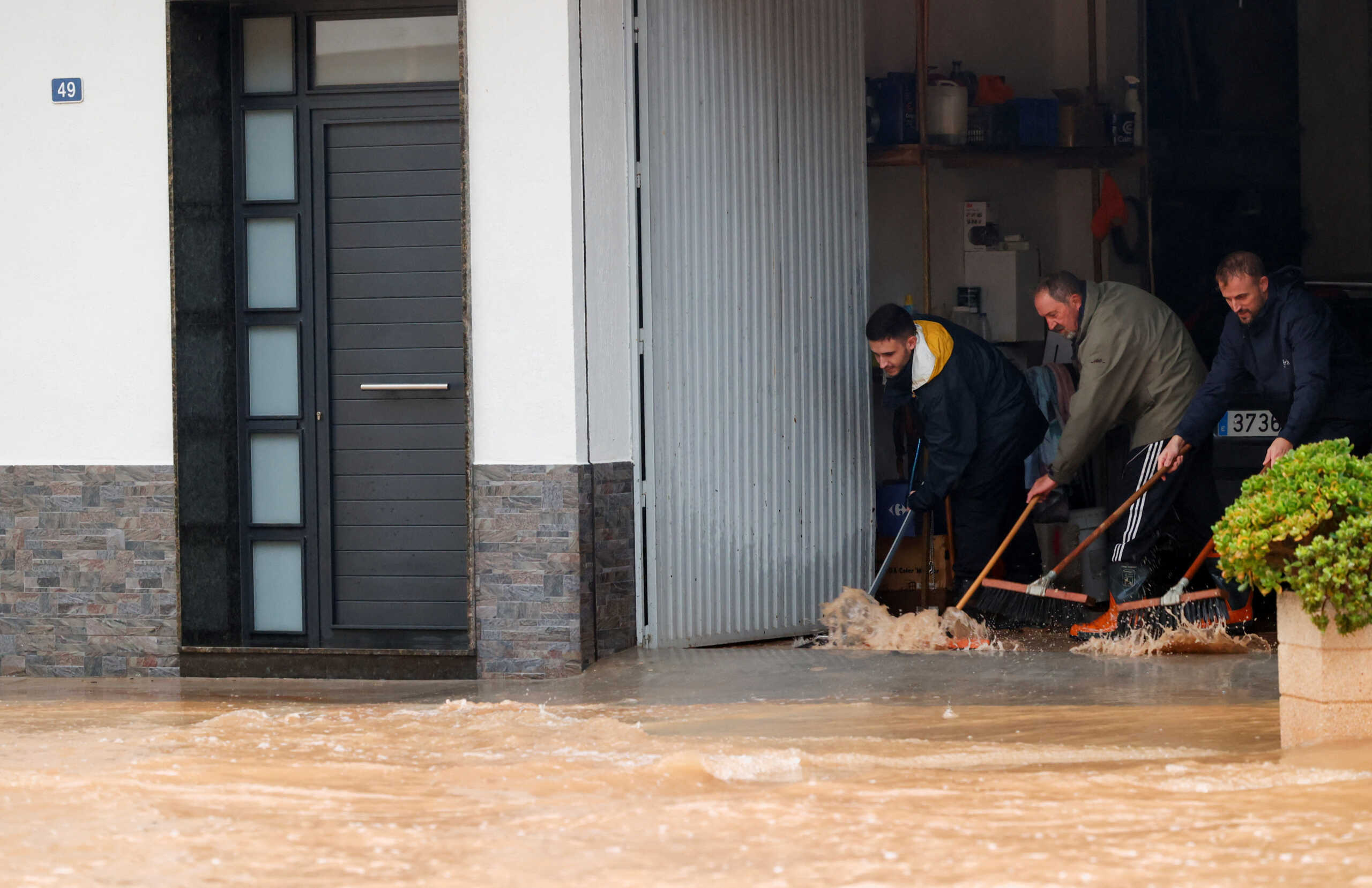 People remove water from a residence after the Spanish meteorological agency put the Valencia region in the highest red alert for extreme rainfalls, in Llombai, Valencia, Spain, October 29, 2024. REUTERS