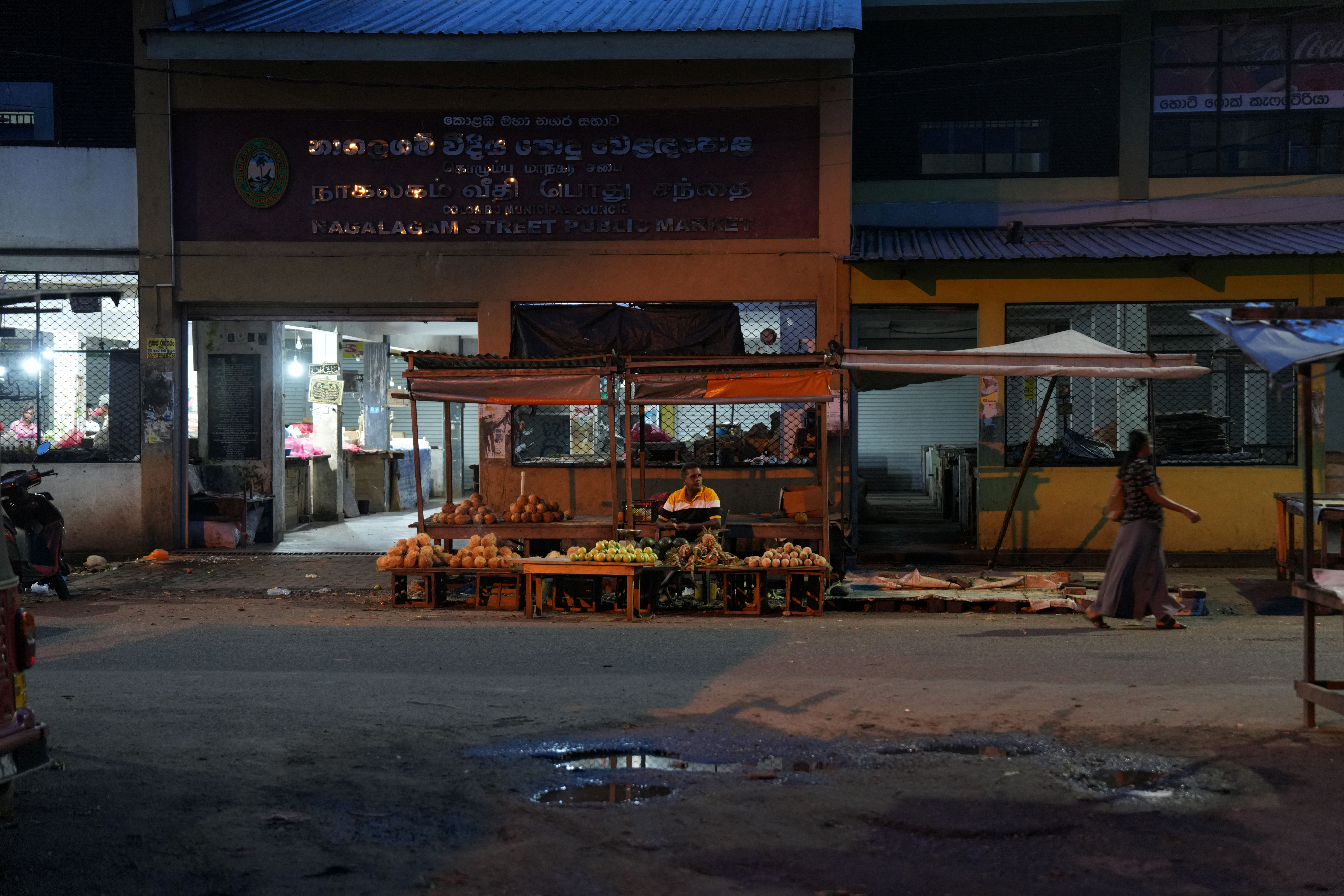 A vendor selling fruits waits for a customer at his roadside stall along a street in Thotalanga, Colombo, Sri Lanka, September 9, 2024. REUTERS