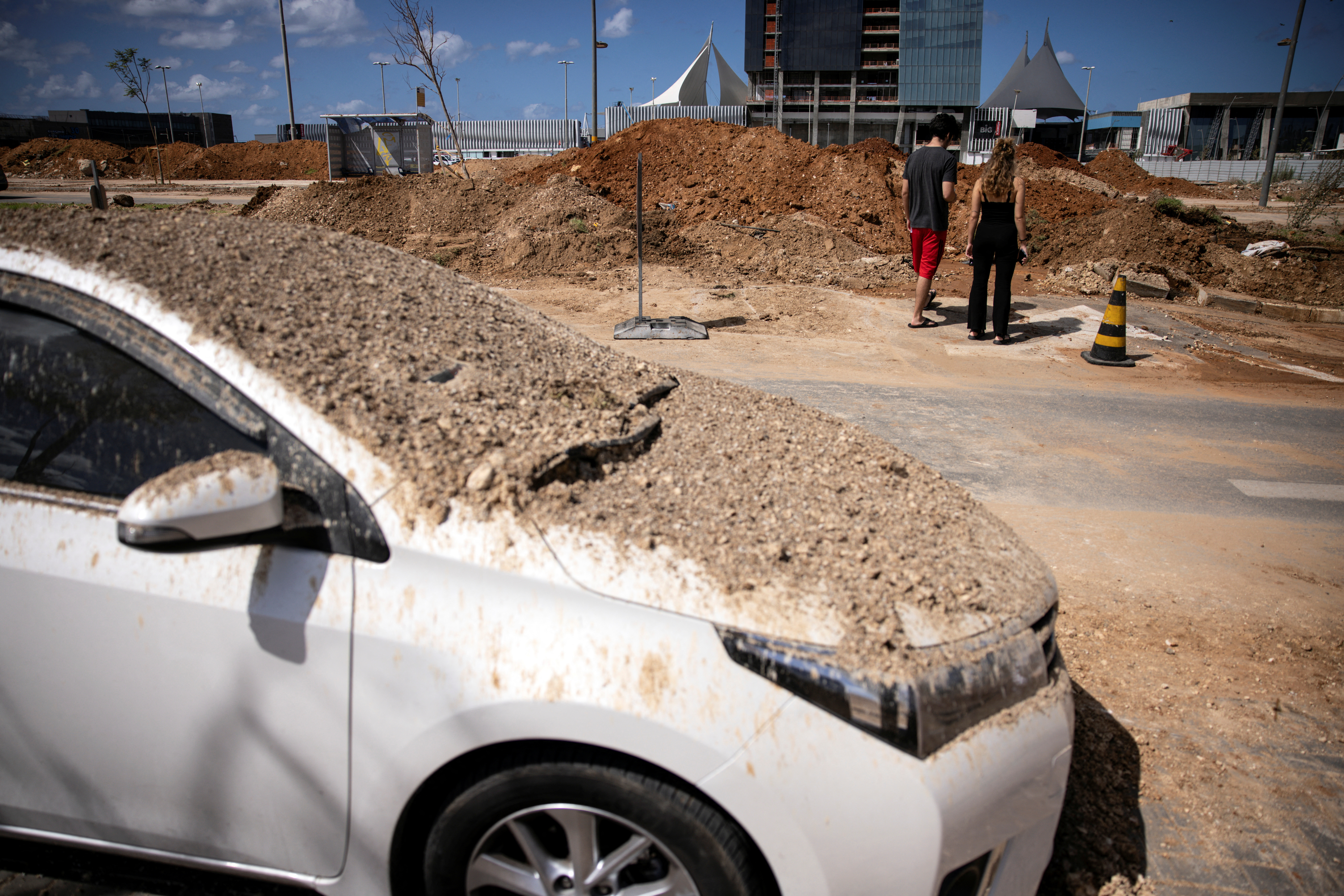 People look at a crater that was later filled in by municipal workers and was caused when Iran fired a salvo of ballistic missiles at Israel, in Tel Aviv, Israel, October 2, 2024. REUTERS