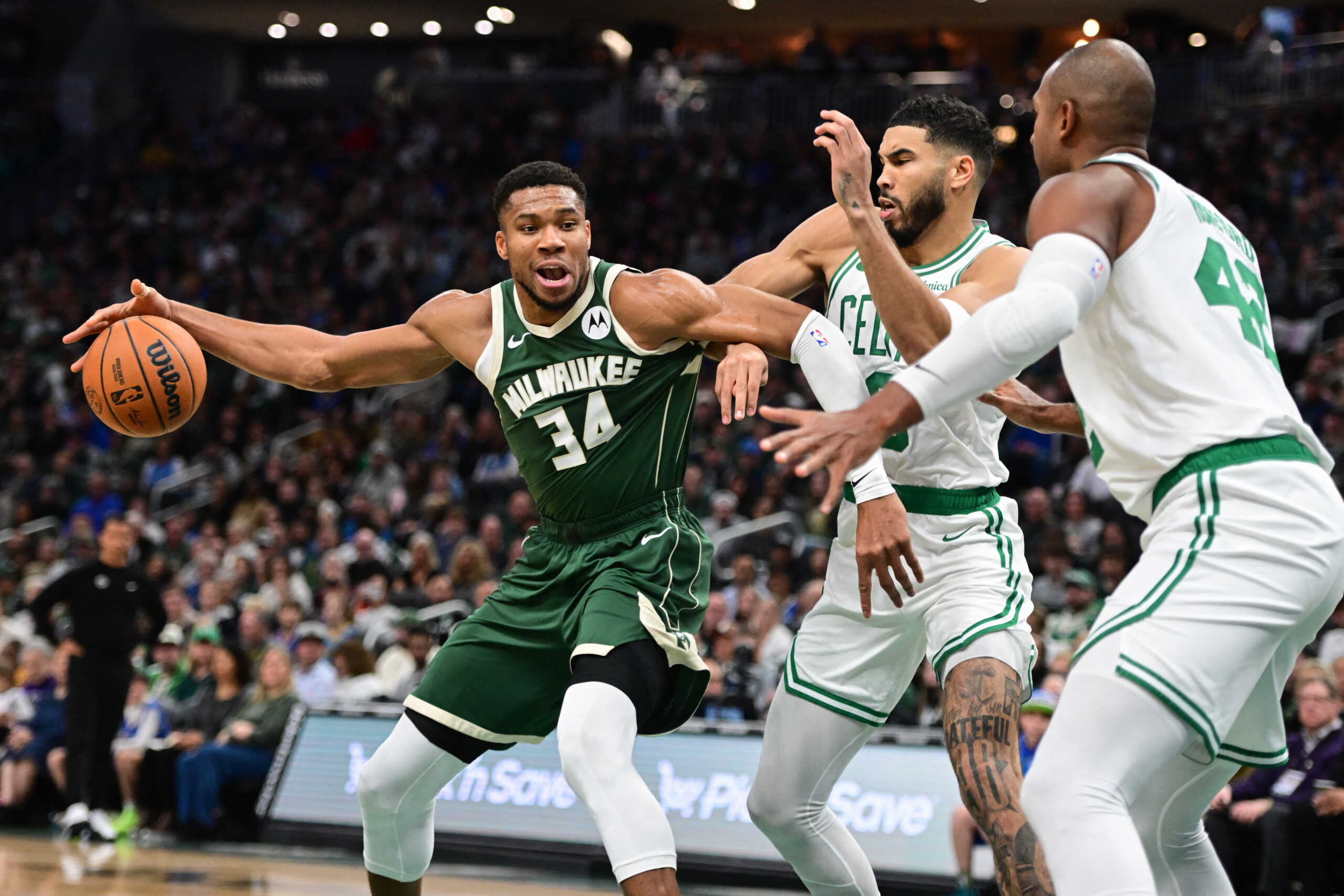 Nov 10, 2024; Milwaukee, Wisconsin, USA; Milwaukee Bucks forward Giannis Antetokounmpo (34) drives for the basket against Boston Celtics forward Jayson Tatum (0) and center Al Horford (42) in the first quarter at Fiserv Forum. Mandatory Credit: Benny Sieu-Imagn Images