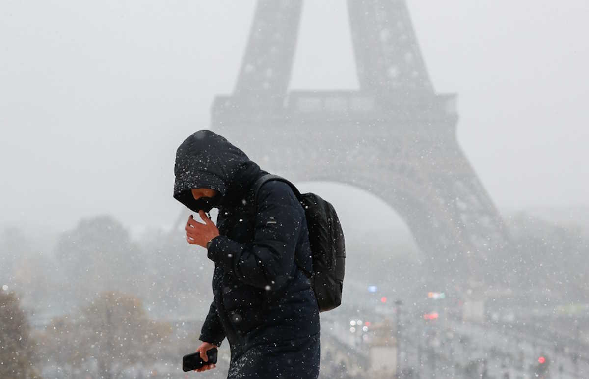 epa11733286 A man walks during snowfall near the Eiffel Tower in Paris, France, 21 November 2024. French National Weather and Climate Service Meteo-France issued an 'orange' warning in 32 departments from northern Brittany and Normandy to the Ile-de-France due to snowfall and freezing rain forecasted on 21 November.  EPA