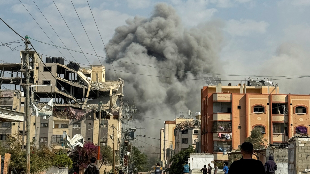 Palestinians watch as smoke rises following Israeli strikes, amid the ongoing conflict between Israel and Hamas, in Nuseirat in the central Gaza Strip, November 1, 2024. REUTERS