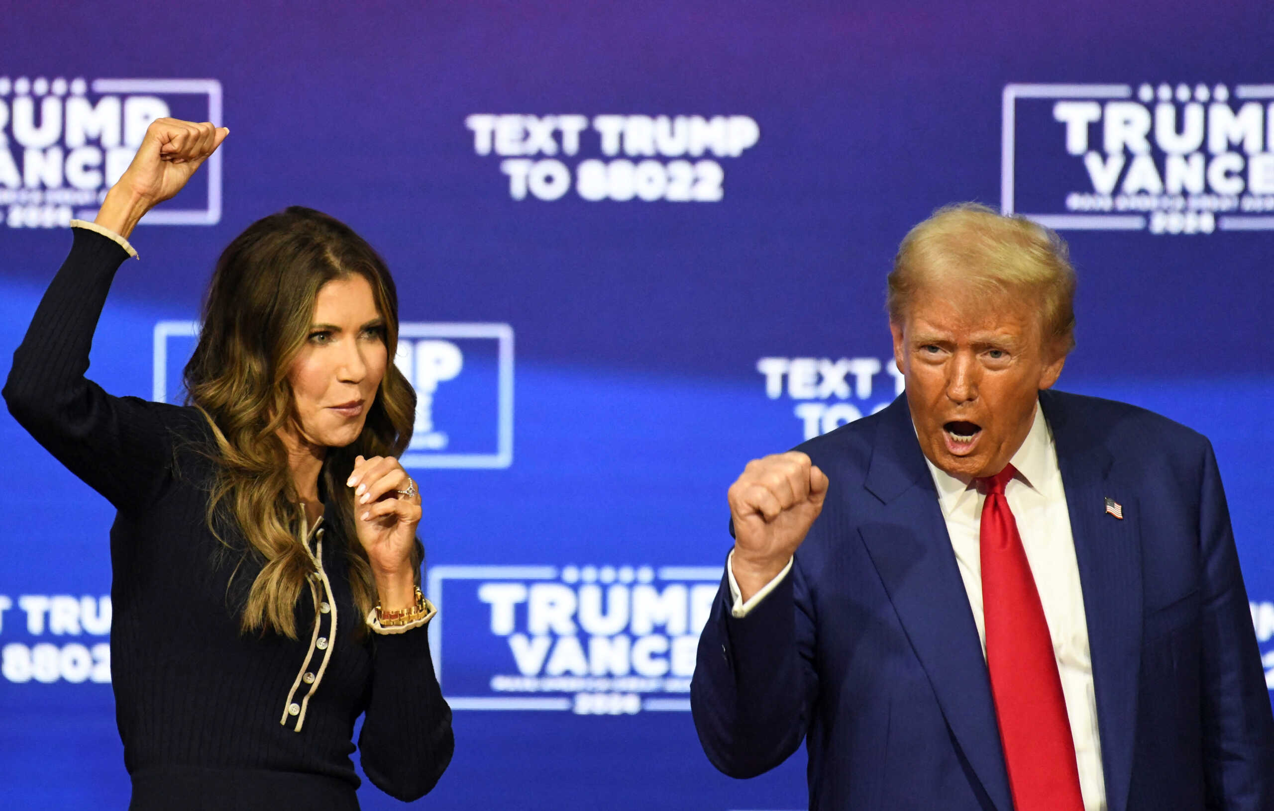 Republican presidential nominee former U.S. President Donald Trump and South Dakota Governor Kristi Noem react during a town hall campaign event in Oaks, Pennsylvania, U.S., October 14, 2024.  REUTERS