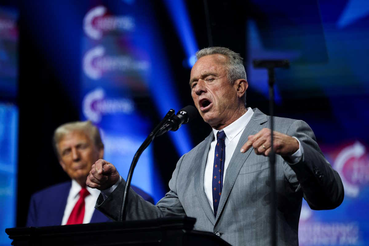 Robert F. Kennedy Jr. speaks as Republican presidential nominee and former U.S. President Donald Trump looks on at a campaign event sponsored by conservative group Turning Point USA, in Duluth, Georgia, U.S., October 23, 2024. REUTERS