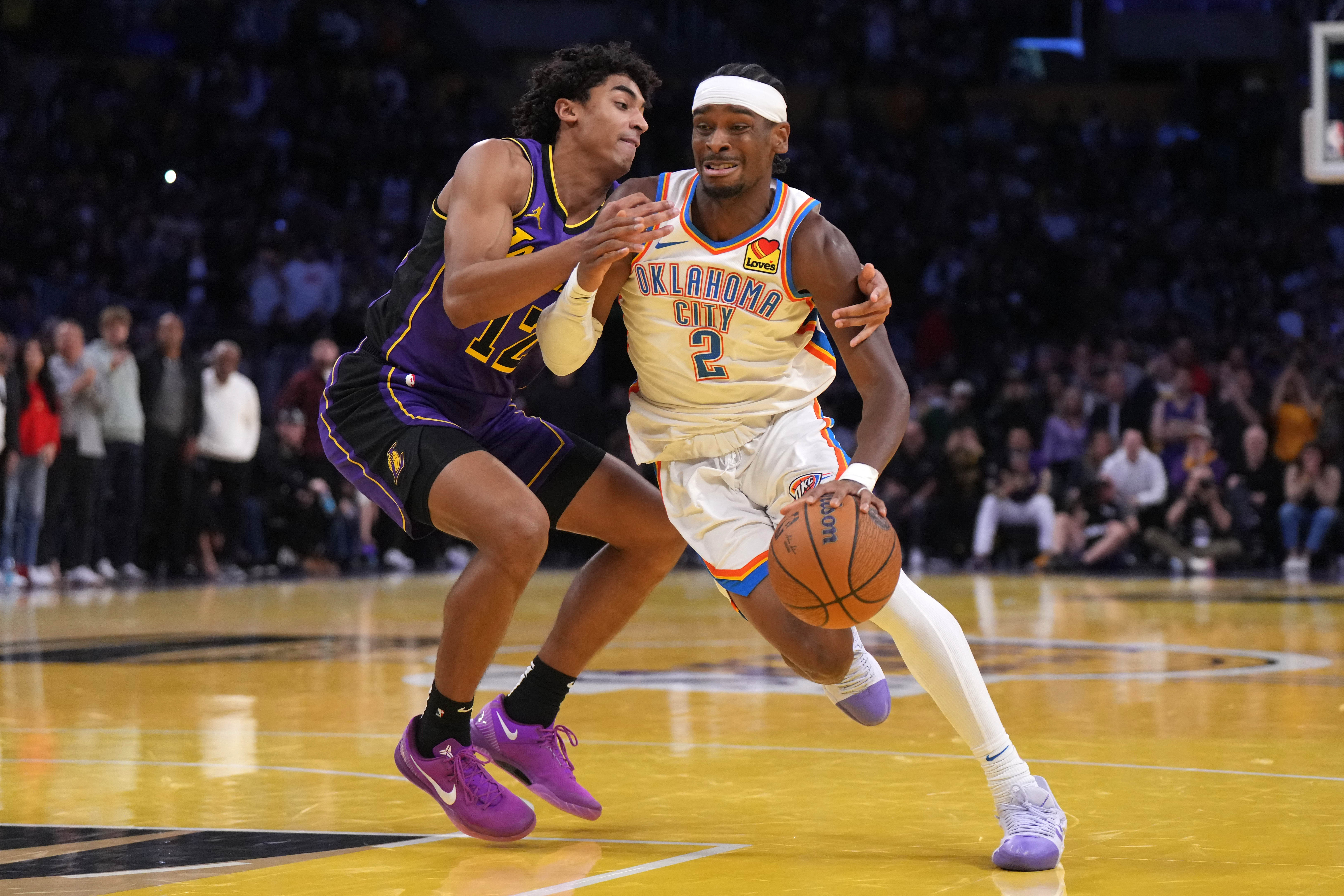 Nov 29, 2024; Los Angeles, California, USA; Oklahoma City Thunder guard Shai Gilgeous-Alexander (2) dribbles against Los Angeles Lakers guard Austin Reaves (15) in the second half at Crypto.com Arena. Mandatory Credit: Kirby Lee-Imagn Images