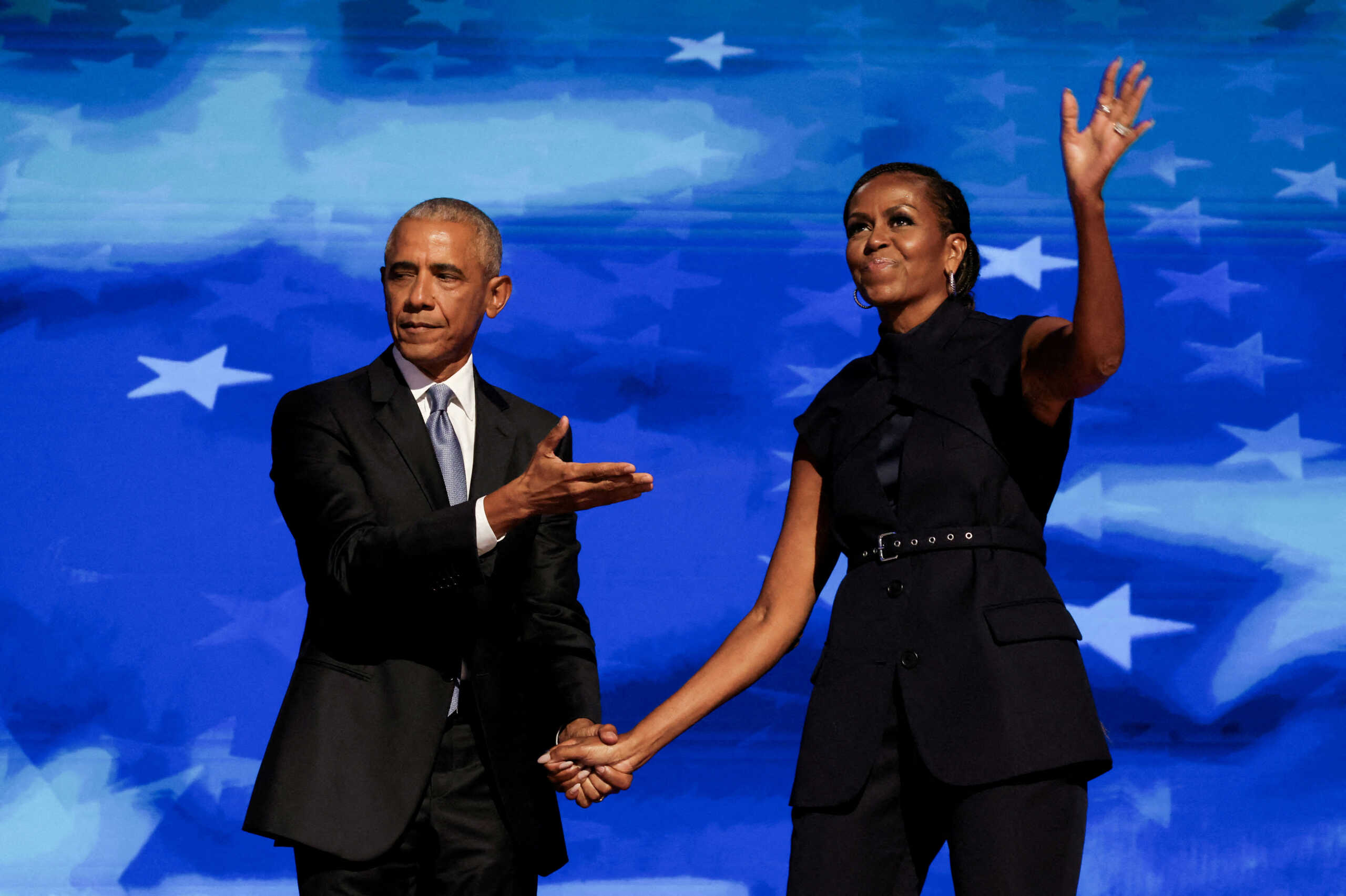 FILE PHOTO: Former U.S. first lady Michelle Obama greets her husband, former U.S. President Barack Obama, on stage during Day 2 of the Democratic National Convention (DNC) in Chicago, Illinois, U.S., August 20, 2024. REUTERS