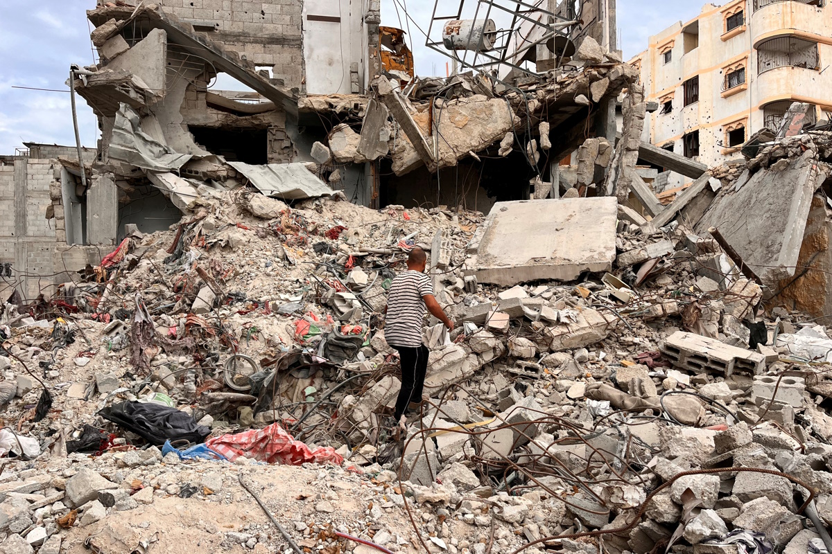 Palestinian man Moein Abu Odeh searches for clothes through the rubble of a house destroyed in the Israeli military offensive, in Khan Younis in the southern Gaza Strip, November 18, 2024. REUTERS