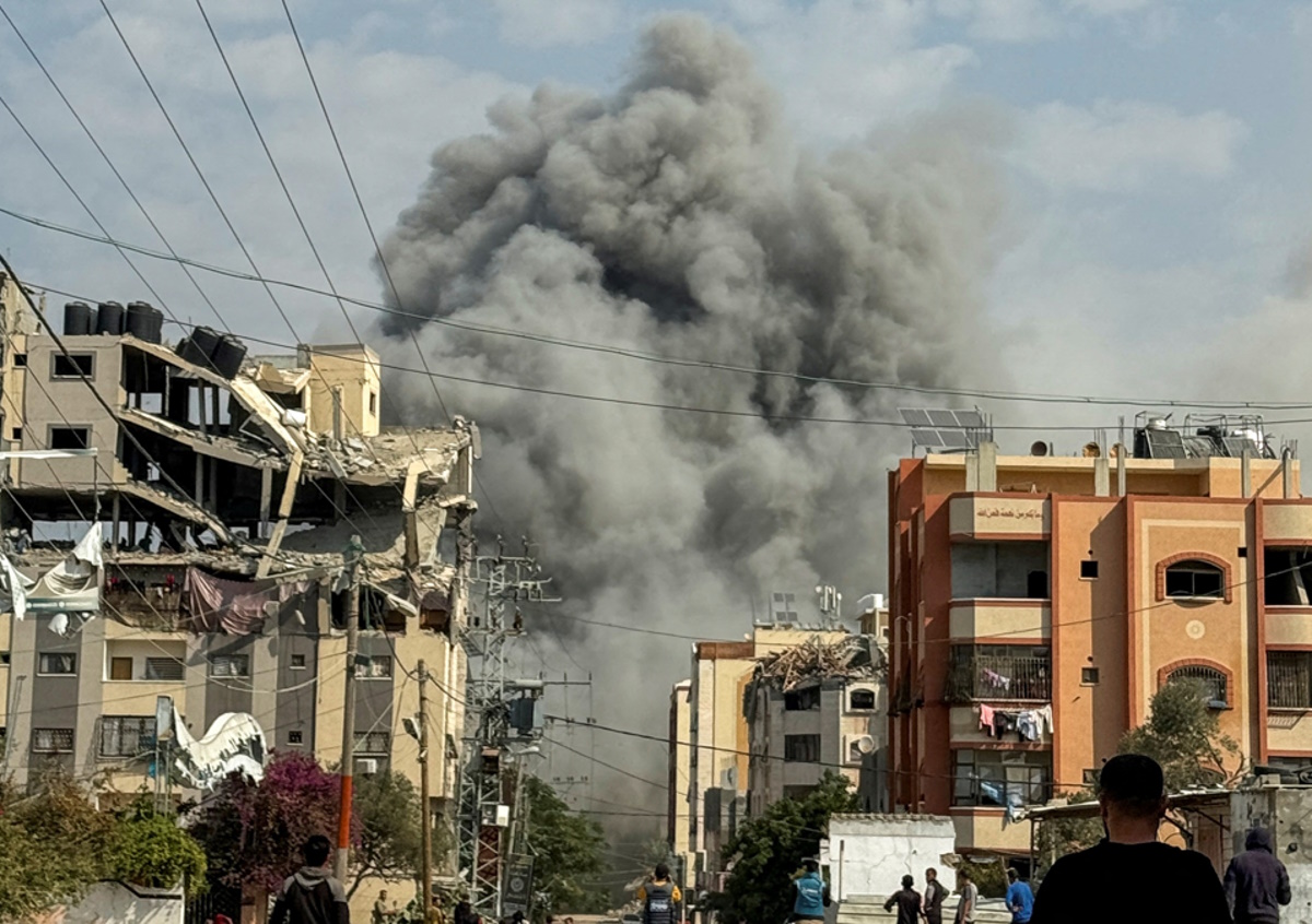 Palestinians watch as smoke rises following Israeli strikes, amid the ongoing conflict between Israel and Hamas, in Nuseirat in the central Gaza Strip, November 1, 2024. REUTERS