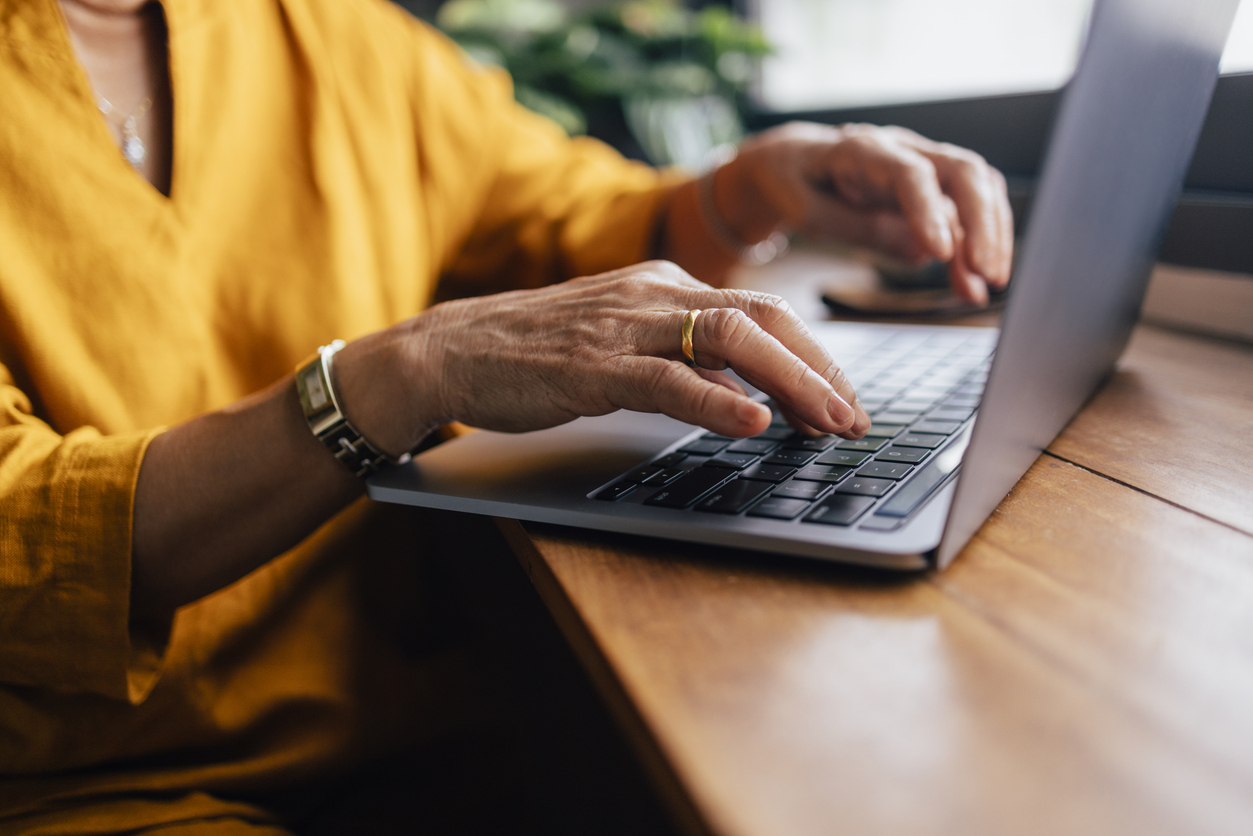 Close up shot of an anonymous woman typing on her laptop.