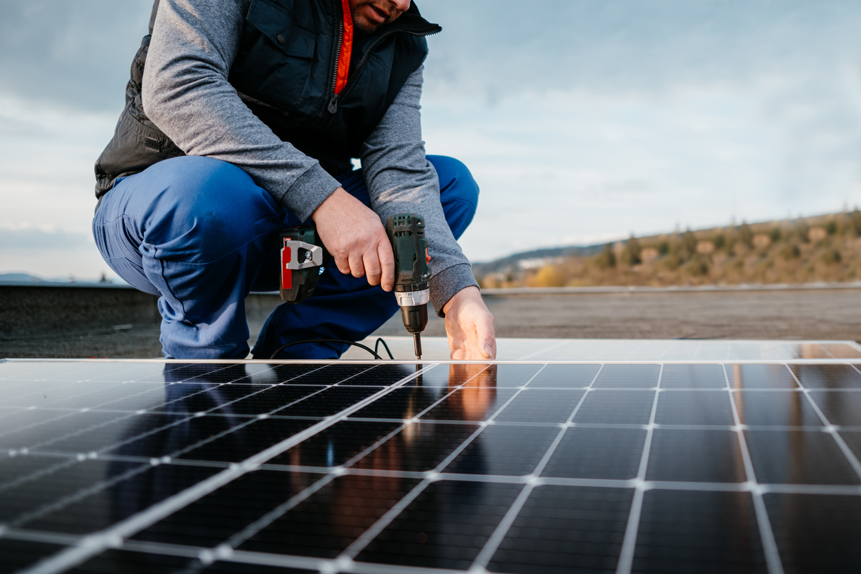 Close up of solar energy technician. Mounting blue solar module. Eco concept alternative energy