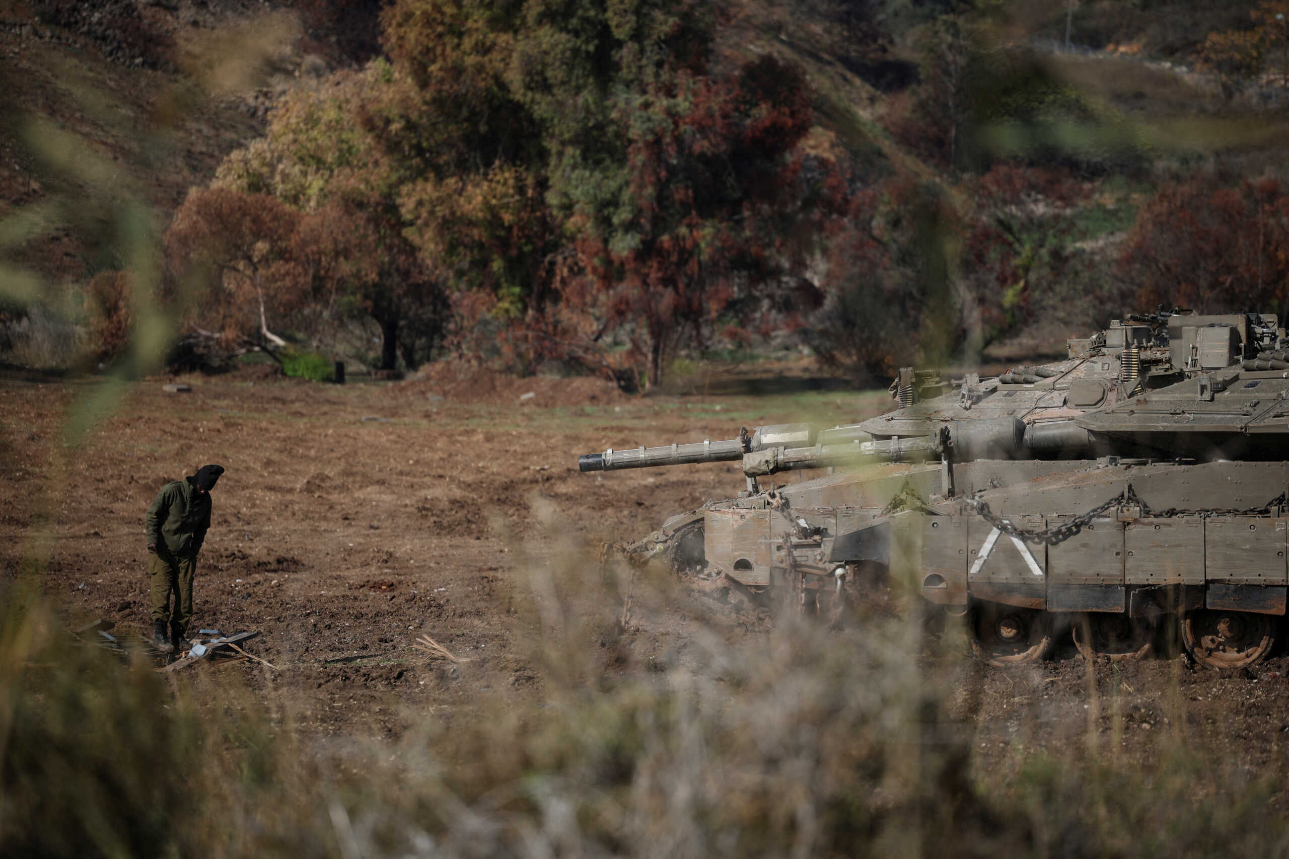 An Israeli soldier stands near military vehicles as they wait in position on the second day of the ceasefire between Israel and Hezbollah, near a road close to the Israel-Lebanon border November 28, 2024. REUTERS