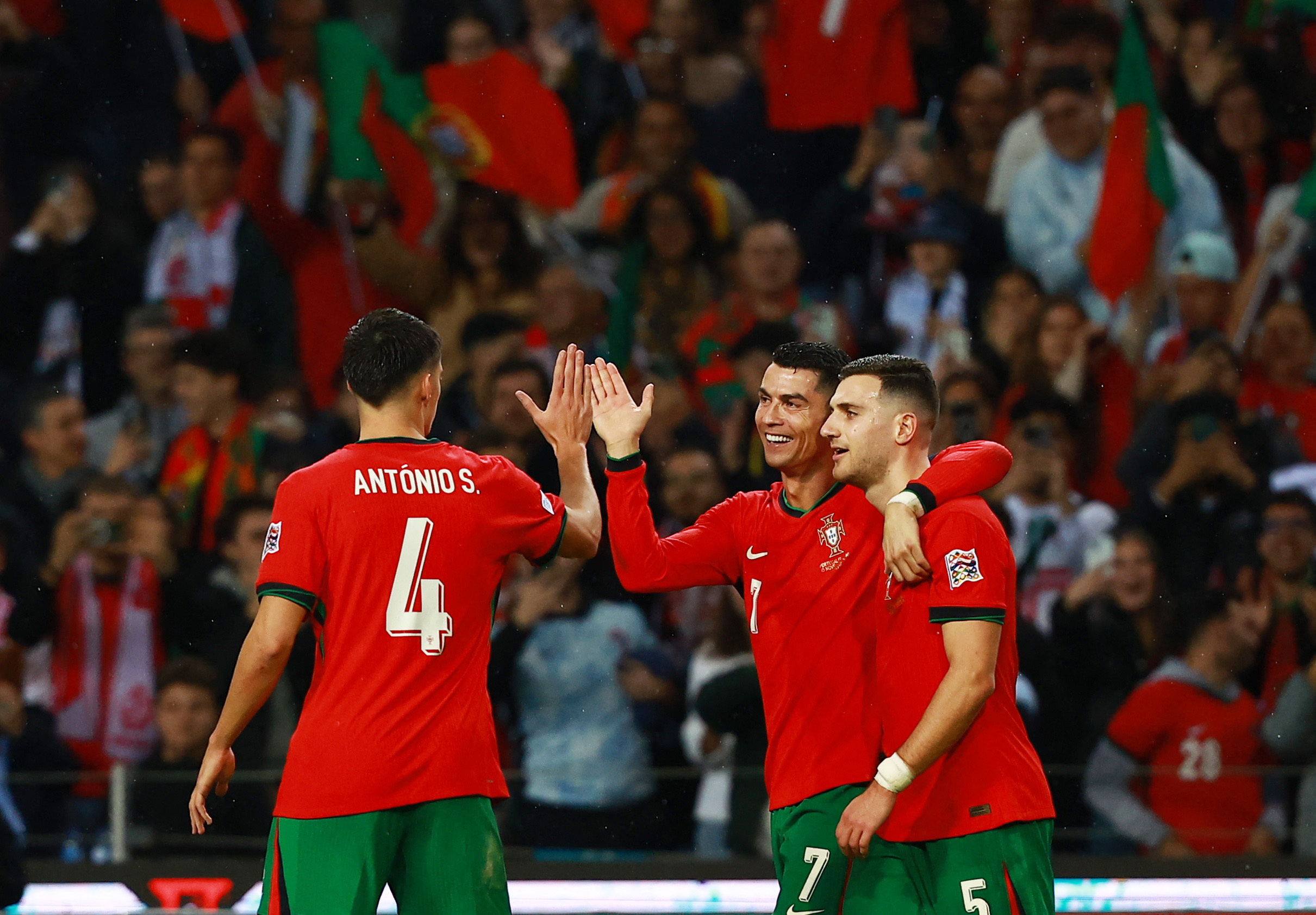 Soccer Football - Nations League - Group Stage - Portugal v Poland - Estadio do Dragao, Porto, Portugal - November 15, 2024 Portugal's Cristiano Ronaldo celebrates with Diogo Dalot and Antonio Silva after scoring their fifth goal REUTERS