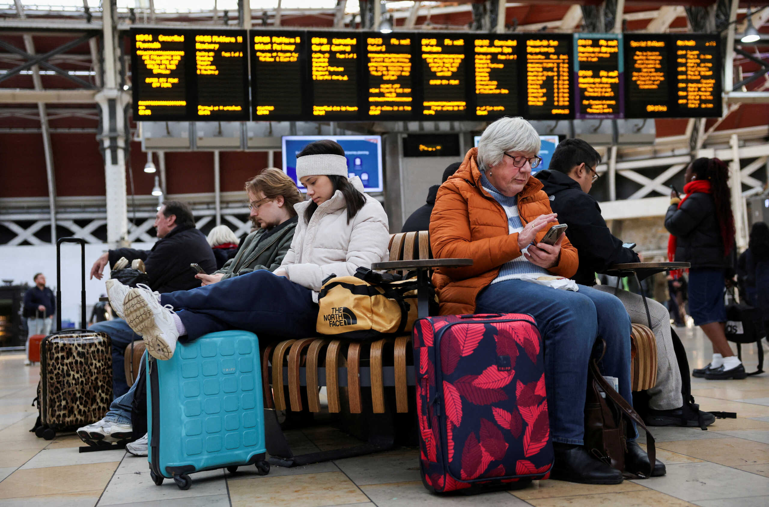 Rail passengers wait with their luggage following train cancellations caused due to Storm Bert at Paddington Station in London, Britain November 25, 2024. REUTERS