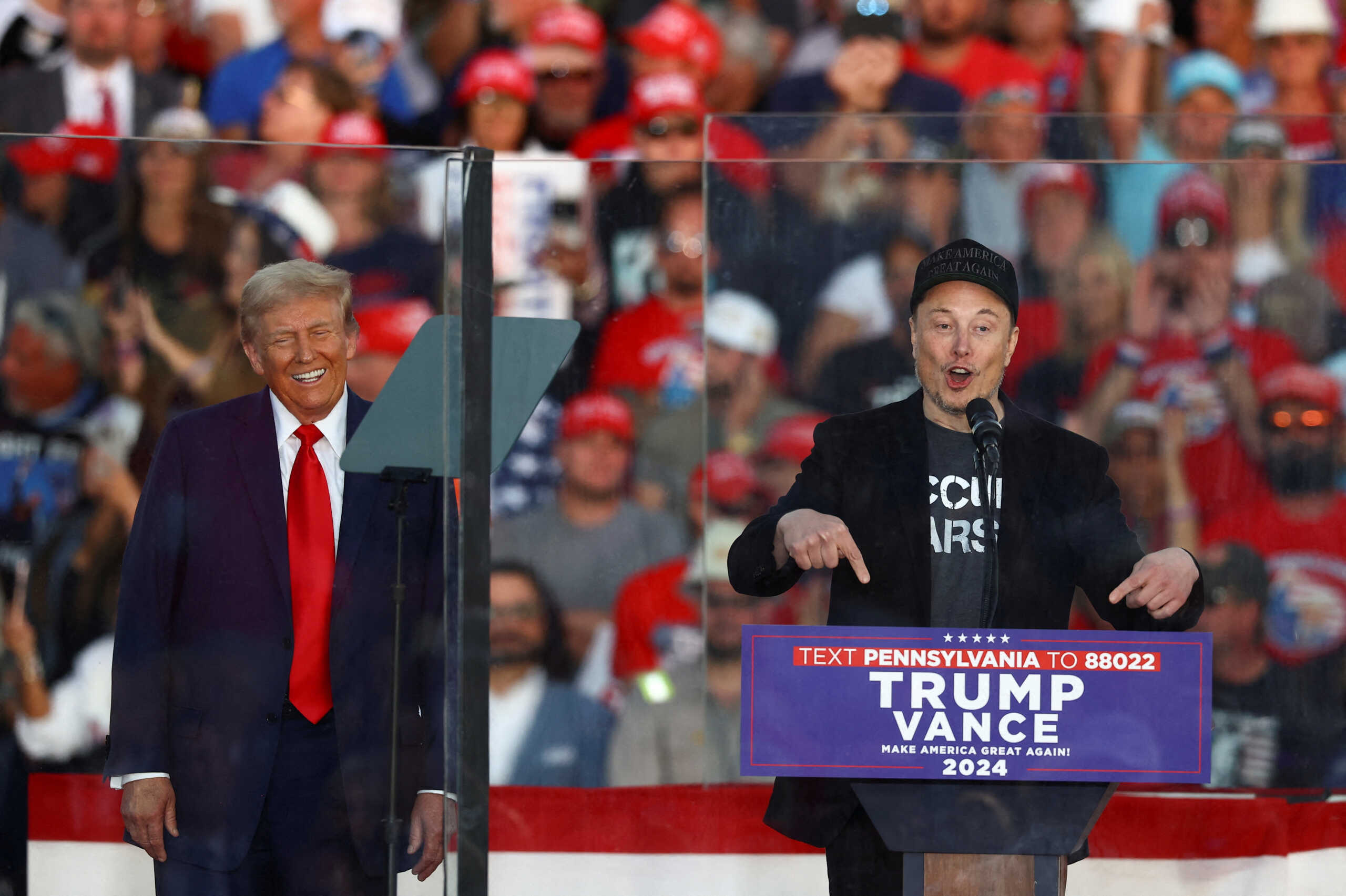 FILE PHOTO: Tesla CEO and X owner Elon Musk speaks as Republican presidential nominee and former U.S. president Donald Trump reacts during a rally at the site of the July assassination attempt against Trump, in Butler, Pennsylvania, U.S., October 5, 2024. REUTERS