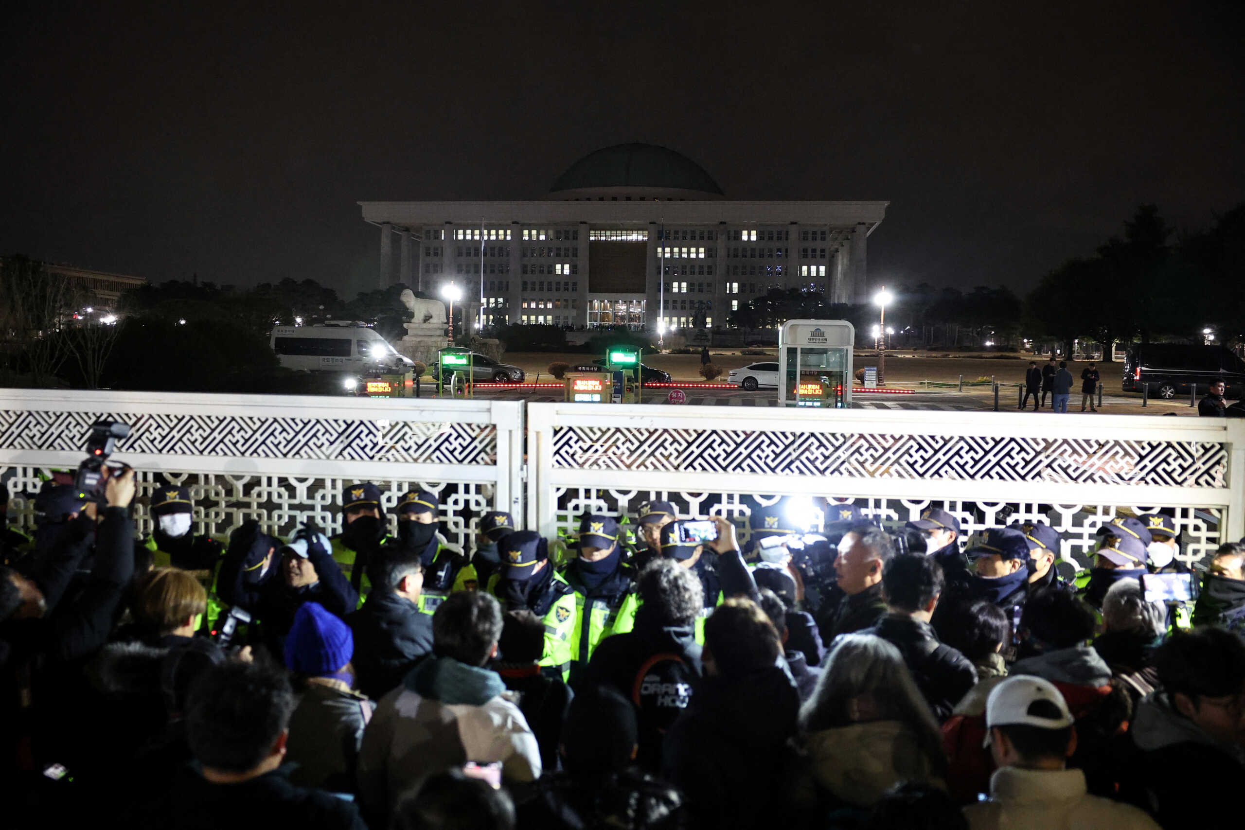 Police officers stand guard at the gate of the National Assembly, after South Korean President Yoon Suk Yeol declared martial law, in Seoul, South Korea, December 4, 2024. REUTERS