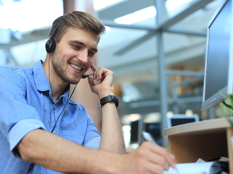 Smiling friendly handsome young male call centre operator