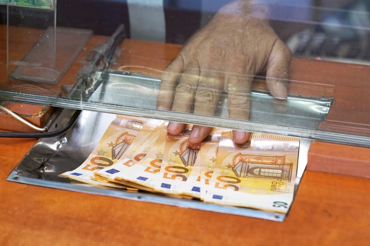 Clerk giving cash money to customer at bank office