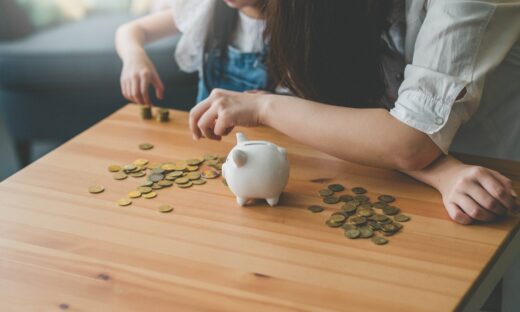 Mother and her daughter count coins from piggy bank