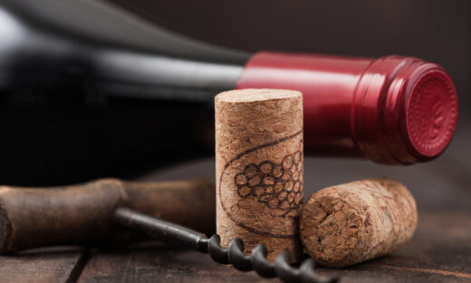 Wine corks with vintage corkscrew on wooden board background