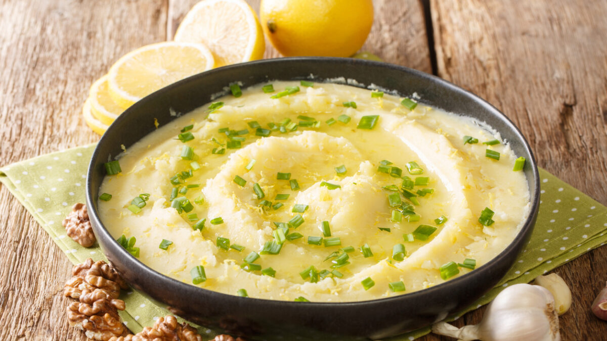 Homemade traditional appetizer Skordalia made of mashed potatoes with garlic, lemon, nuts and olive oil close-up on a plate on the table. horizontal