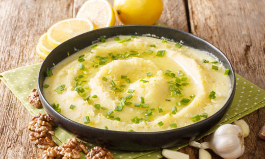 Homemade traditional appetizer Skordalia made of mashed potatoes with garlic, lemon, nuts and olive oil close-up on a plate on the table. horizontal