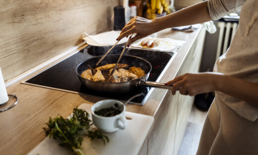 Woman preparing red mullet fishes in home kitchen