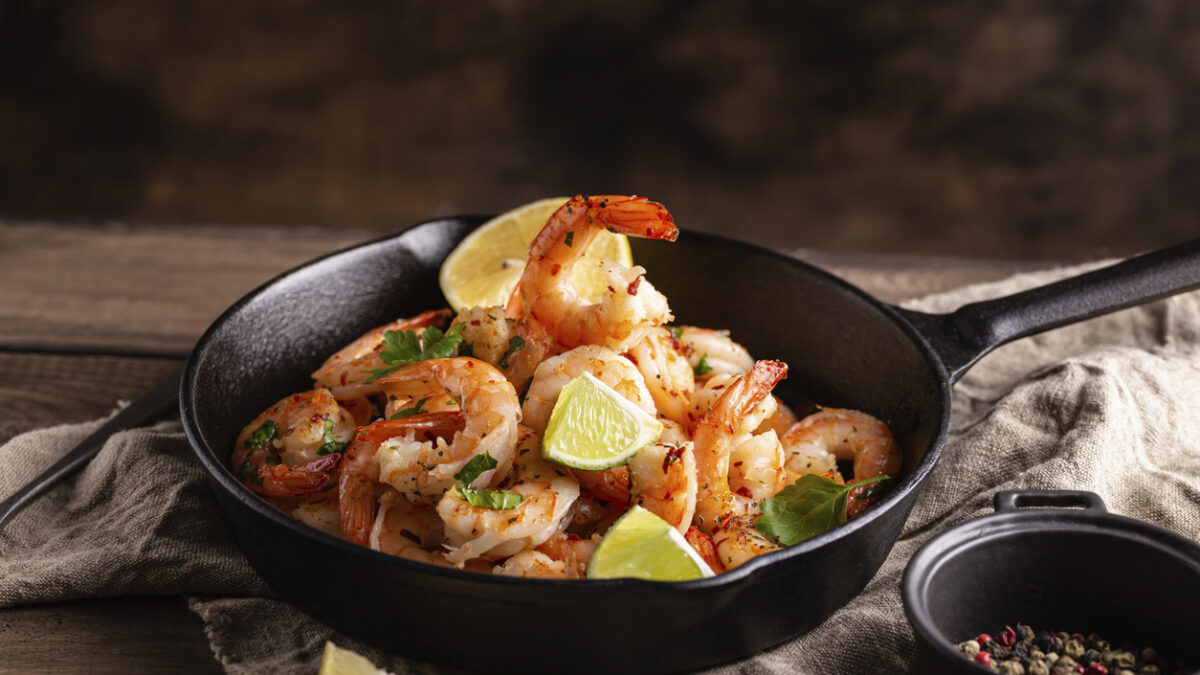 Grilled shrimps with greens and garlic in a pan