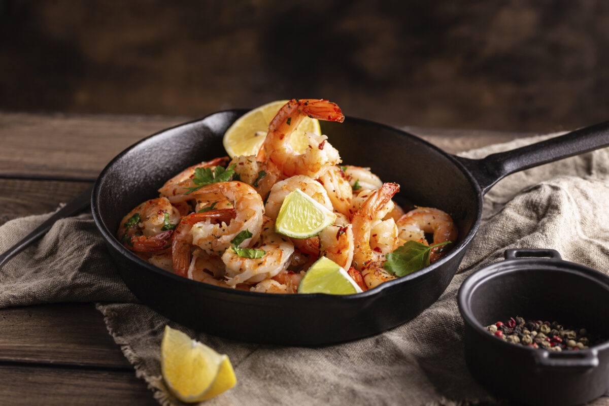 Grilled shrimps with greens and garlic in a pan