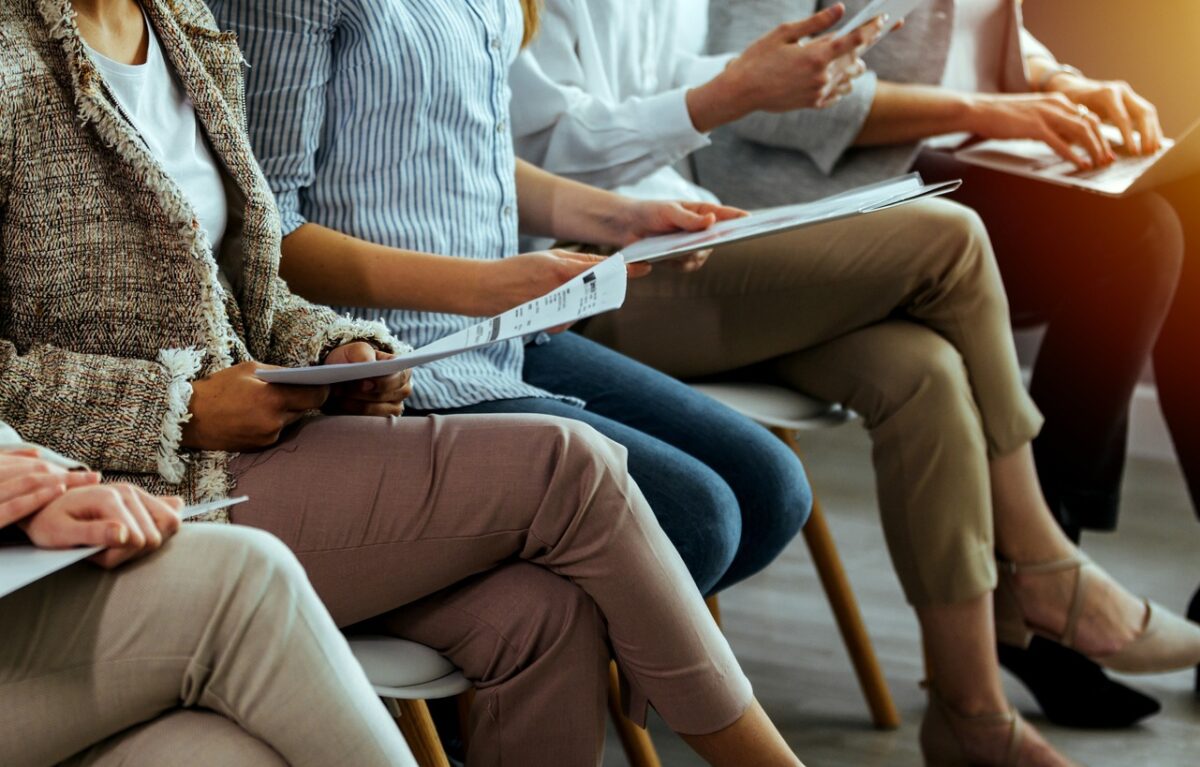 business people sitting on chairs in waiting room