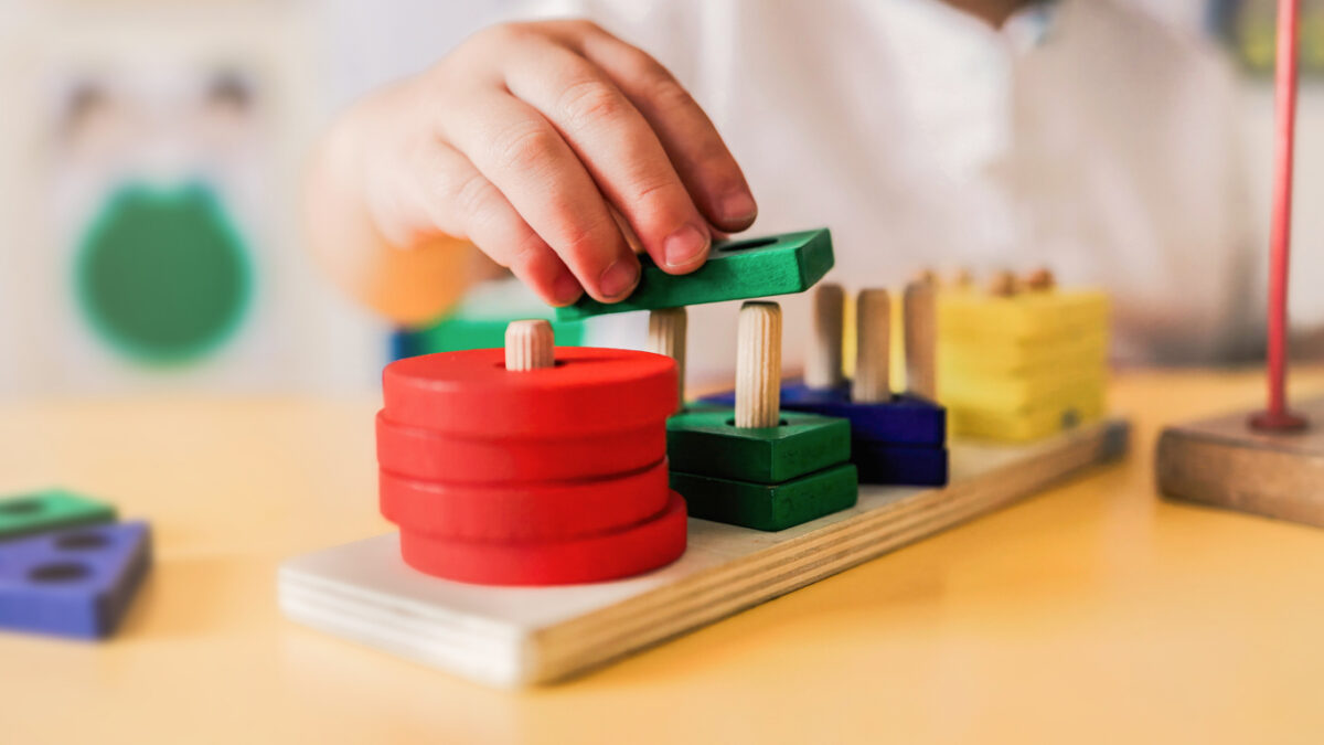 Kid playing with wood toys