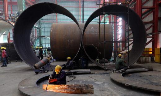 A worker cuts a metal plate inside an industrial tank manufacturing factory on the outskirts of Ahmedabad, India, January 31, 2025. REUTERS