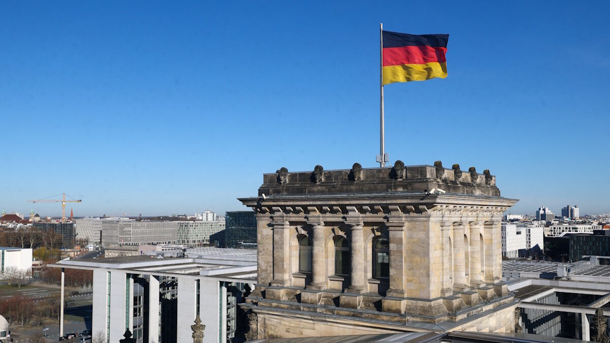 German national flag flutters on top of the Reichstag building