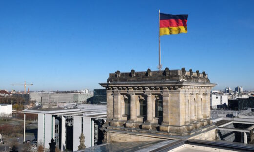 German national flag flutters on top of the Reichstag building