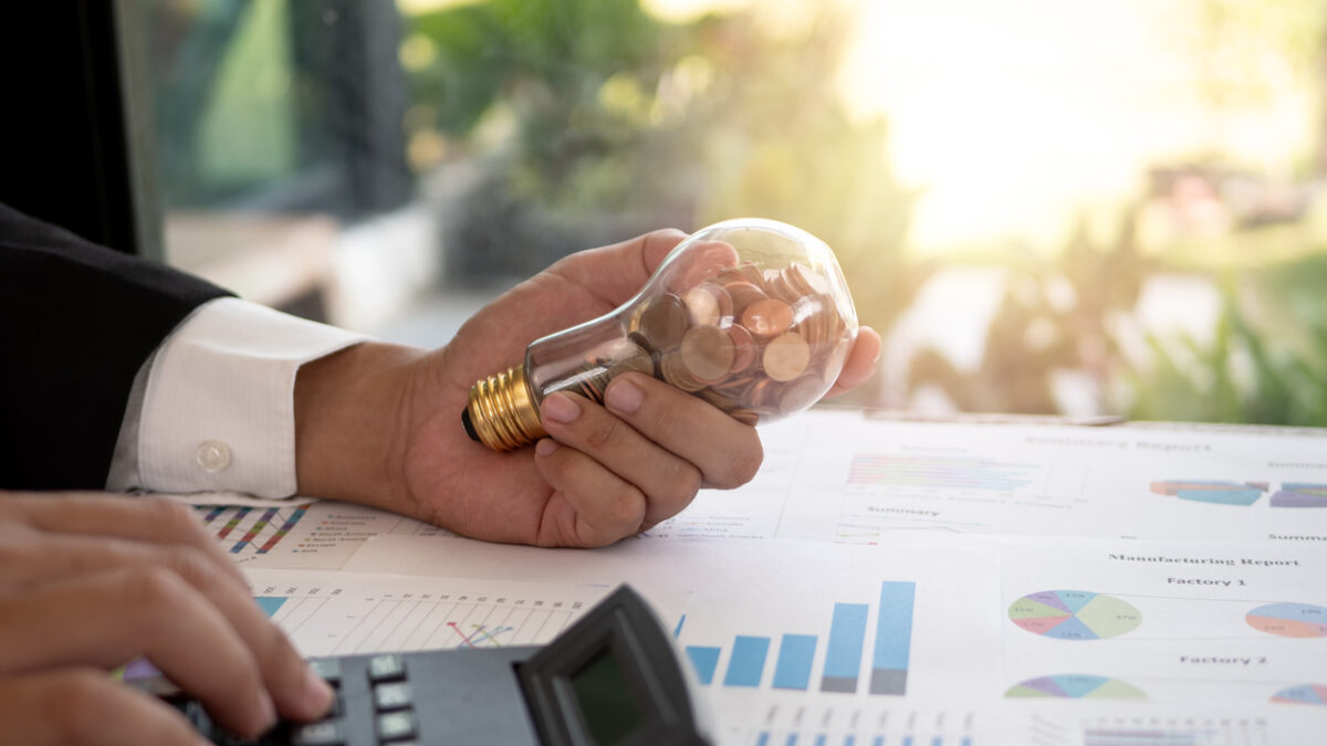 Hand of businessman hold light bulb with coin