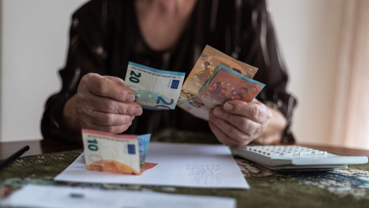 Senior man's hands holding Euro banknote