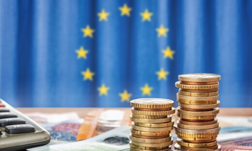 coins in front of the flag of the European Union