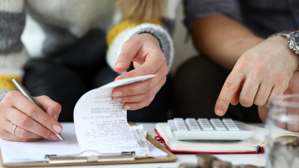 Close-up view of man and woman calculating expenses