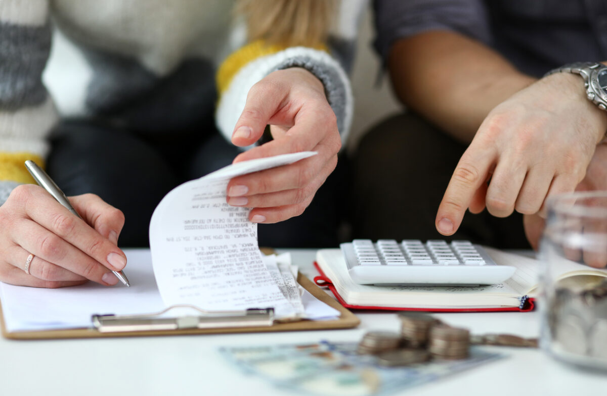 Close-up view of man and woman calculating expenses