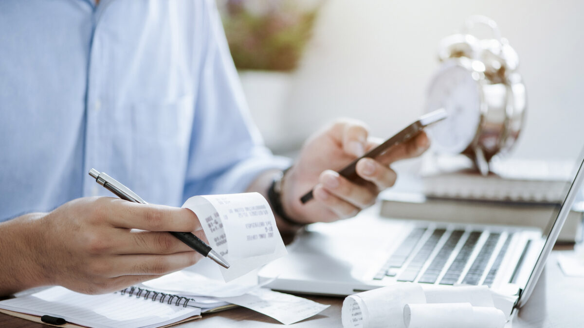 young man holding pen with bills working for calculate business data, taxes, bills payment,