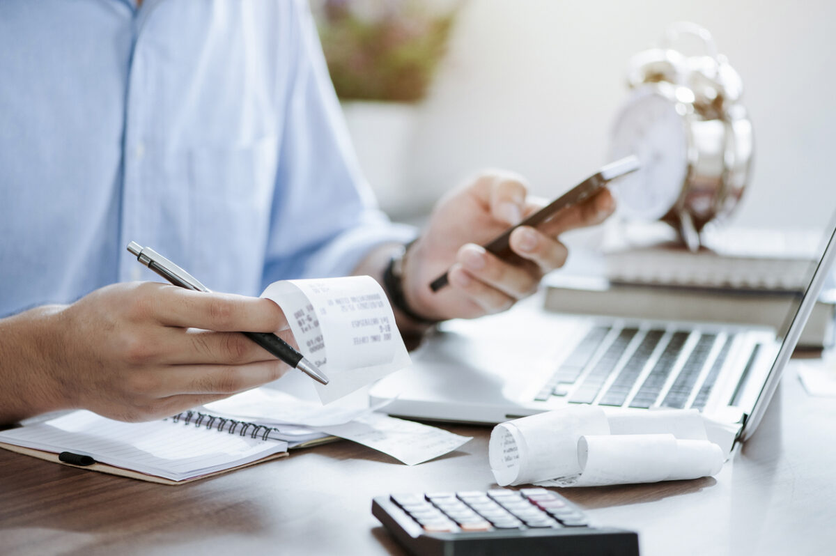 young man holding pen with bills working for calculate business data, taxes, bills payment,