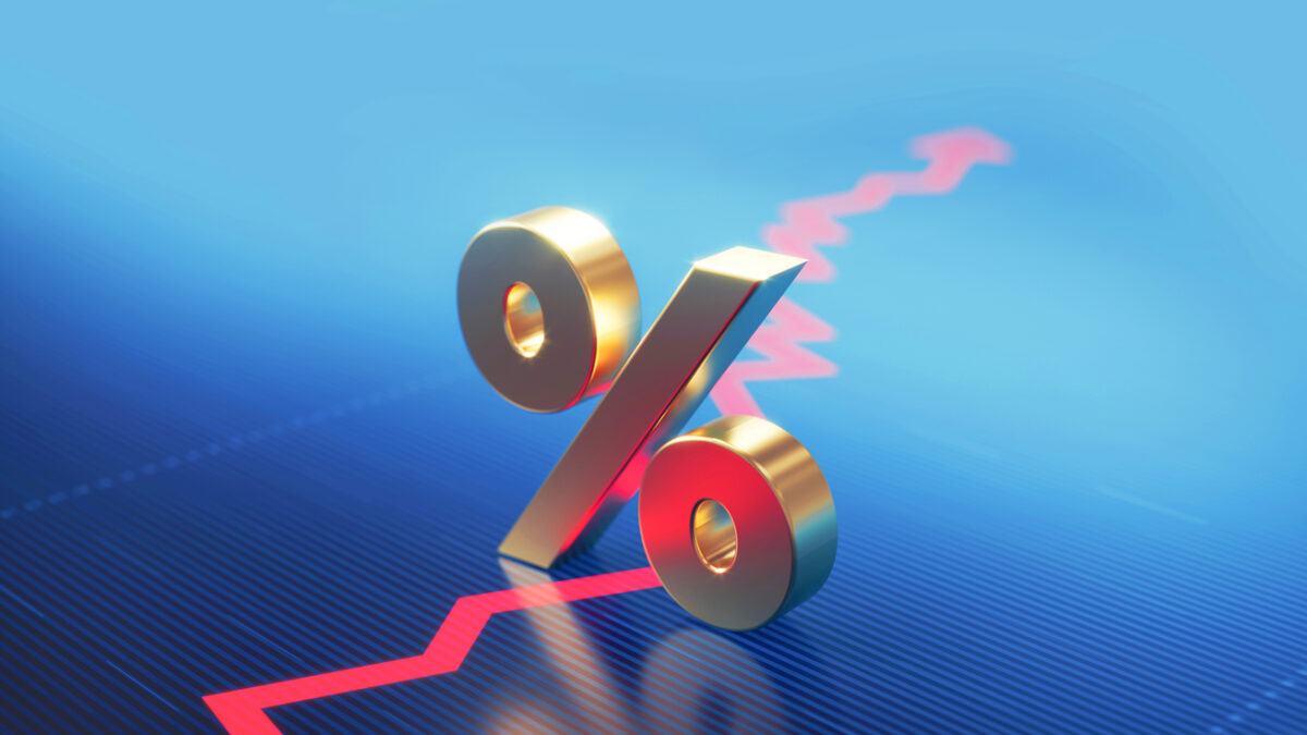 Percentage sign standing over a financial graph